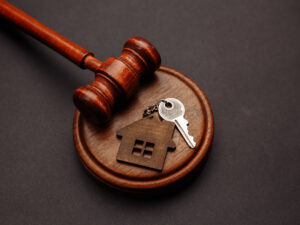 Judge gavel and keyt of house on wooden background. Concept of real estate law